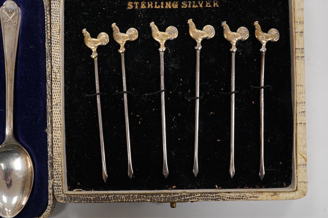 A collection of assorted silver to include five napkin rings including two pairs, a cased pair of glass butter dishes with silver butter knives, five golf related teaspoons, a cased set of six sterling cocktail sticks wi